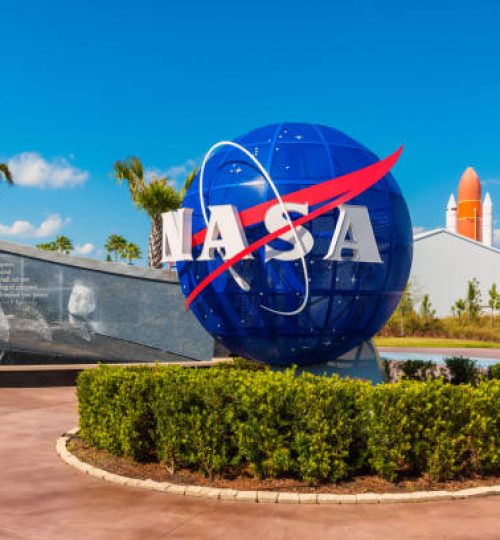 Cape Canaveral, FL, USA - April 1, 2015: NASA Logo on Globe at Kennedy Space Center Visitor Complex in Cape Canaveral, Florida, USA. To the left is a painting visible of President John F. Kennedy.